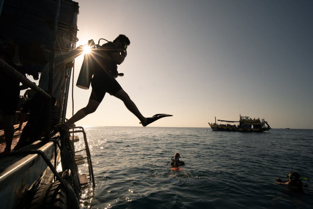 An SSI diver juming into the water for a night dive