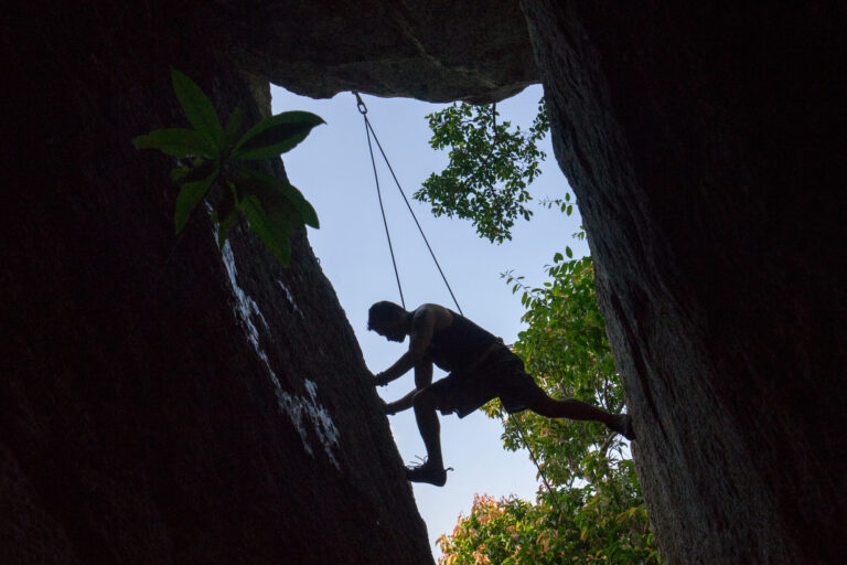 Home 11 a man on a rock using the koh tao climbing guidebook