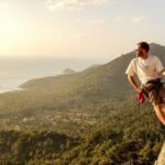 Advanced Rock Climbing Course a man on a rock with a rope and a mountain in the background on Koh Tao