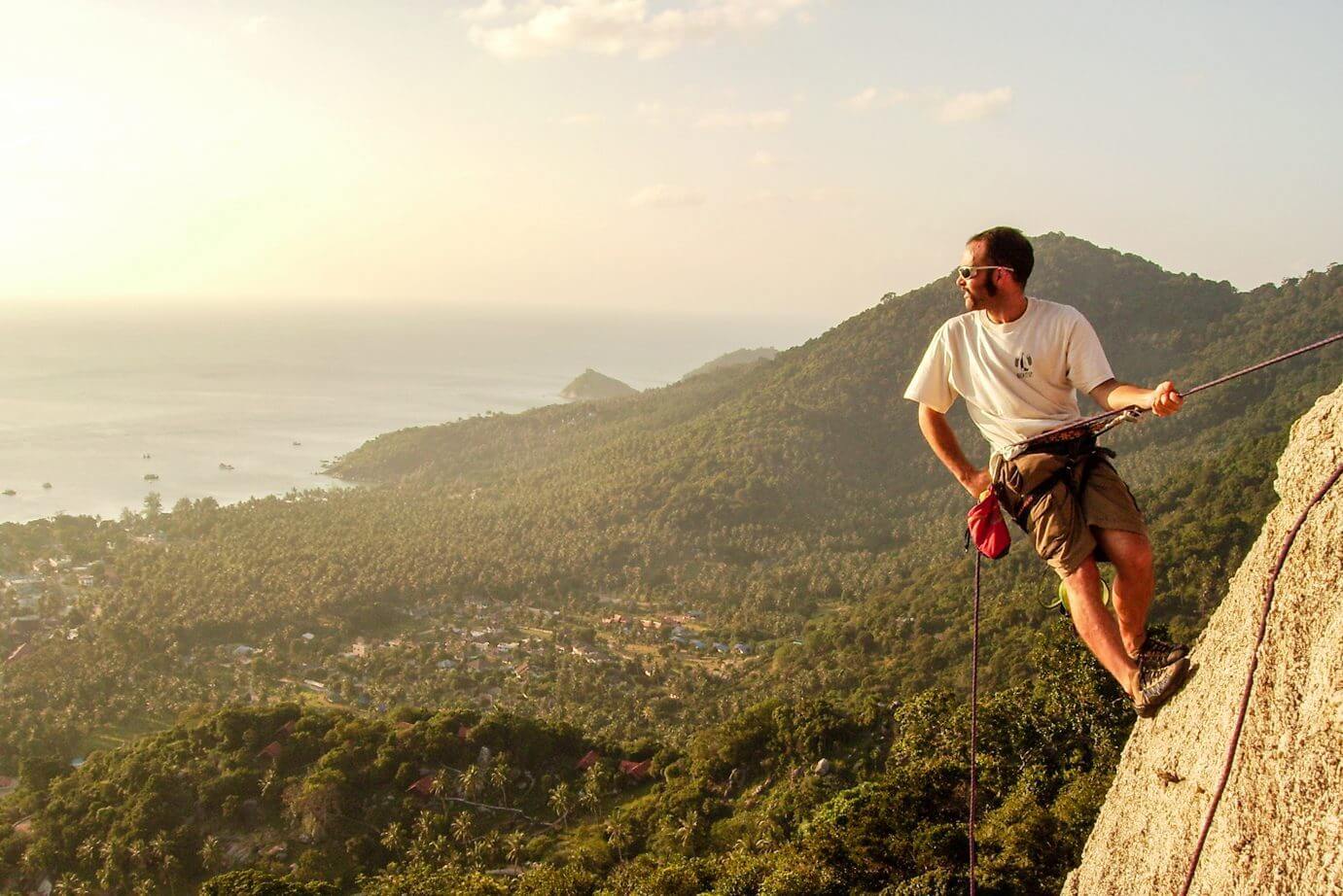 Climbing Guidebook 2 Advanced Rock Climbing Course a man on a rock with a rope and a mountain in the background on Koh Tao